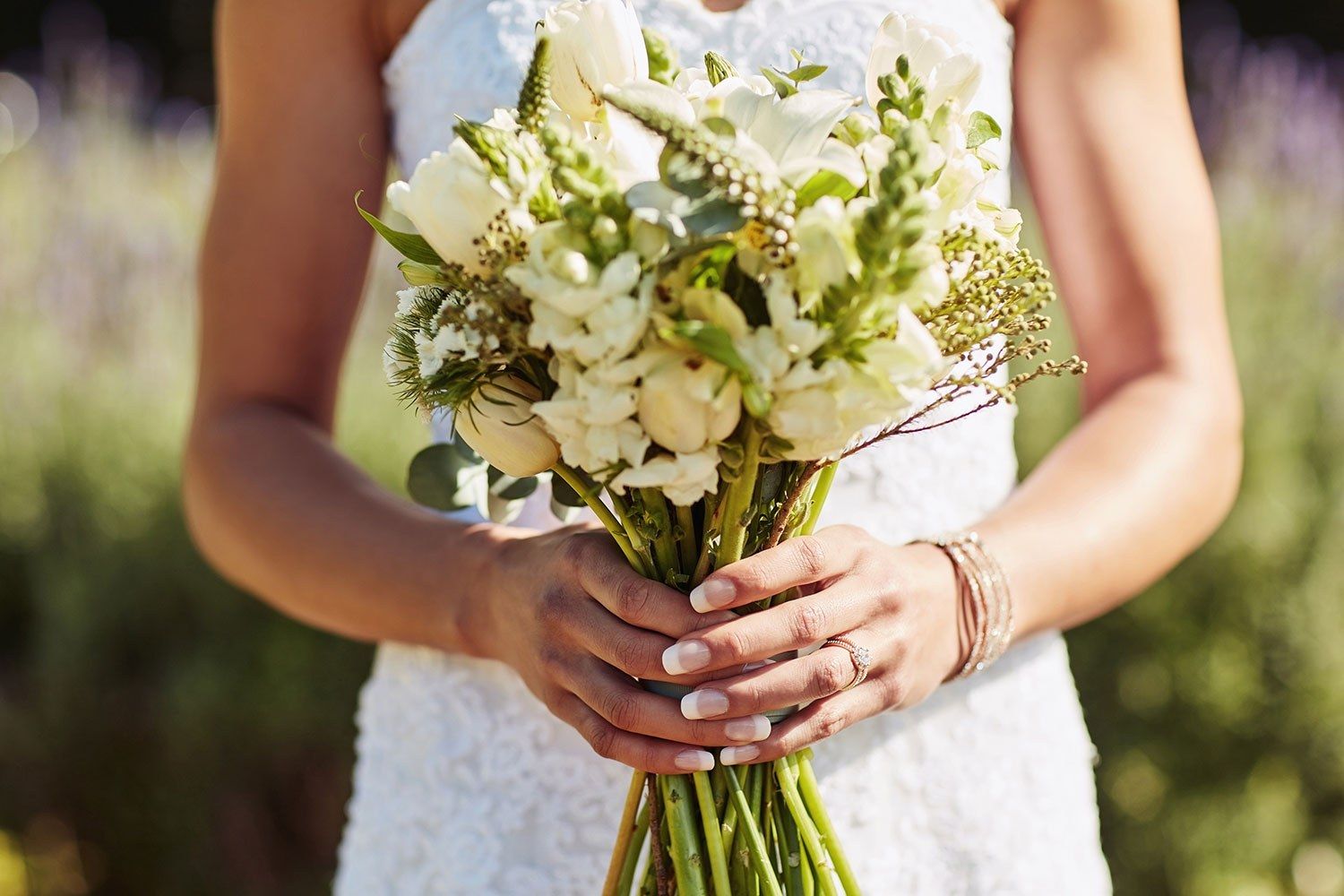 Una novia sostiene su ramo de flores blancas